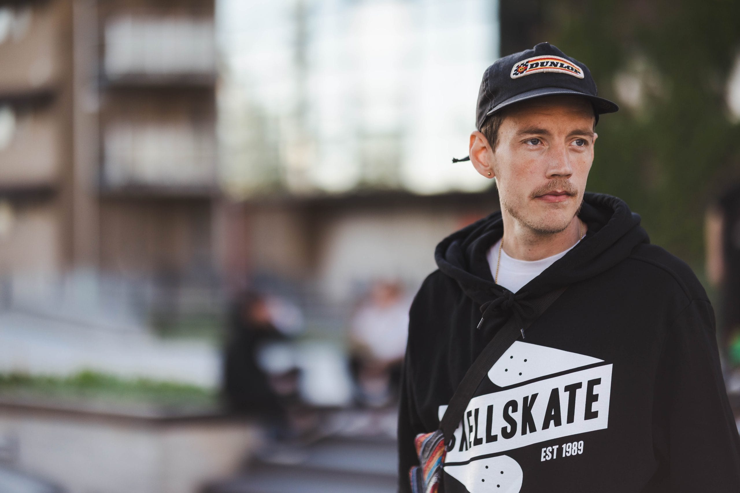Ung man i keps och skatehoodie utomhus